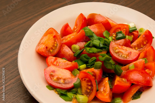 salad of small cherry tomatoes and green onions in a ceramic plate