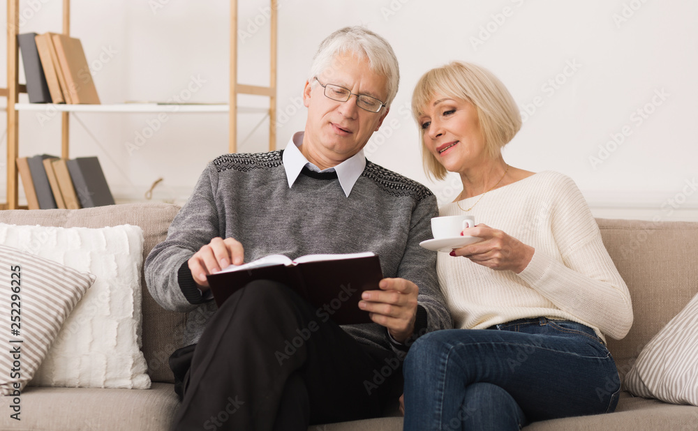 Elderly couple spending time together and reading book