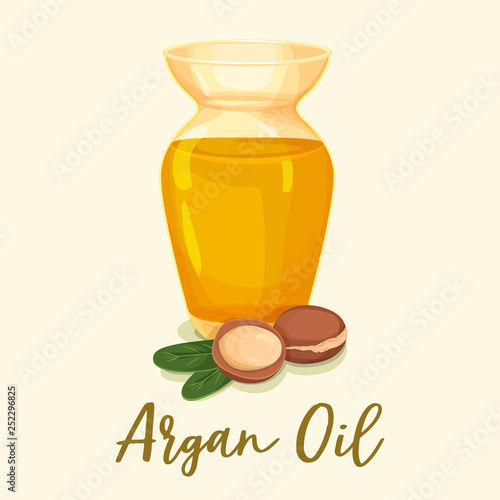 Argan oil in bottle near leaves and tree nuts