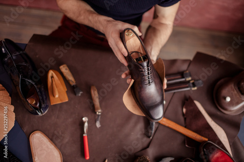 beautiful repaired shoes in man's hands. close up top view photo photo