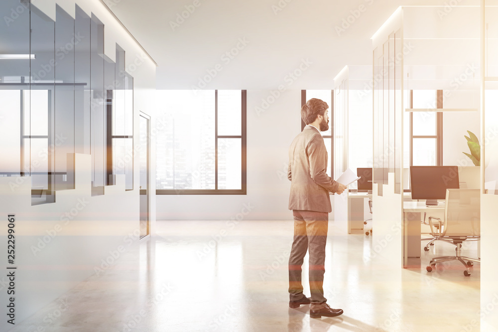 Man in white and glass open space office lobby Man in white and glass open space office lobby