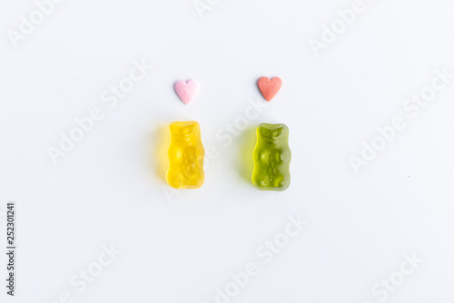 romantic gummy bears with hearts on the head on white background
