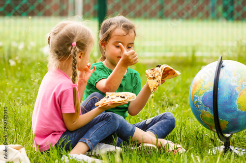 Children eating pizza in park photo