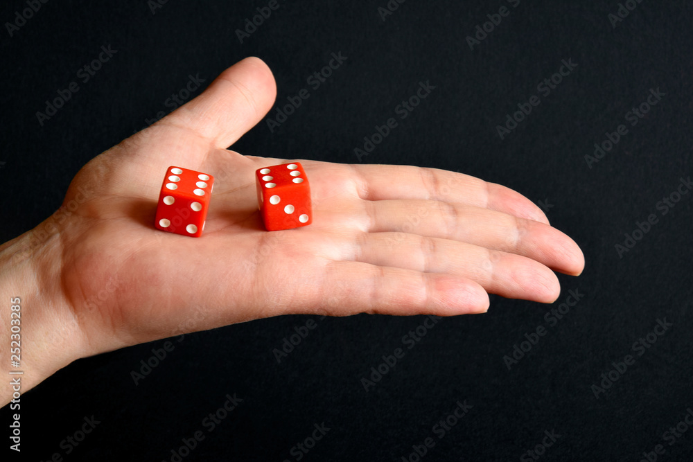 Red game cubes on the male palm, gaming dice close up, selective focus. Board games. Red game cubes on the male palm, gaming dice close up, selective focus. Board games.