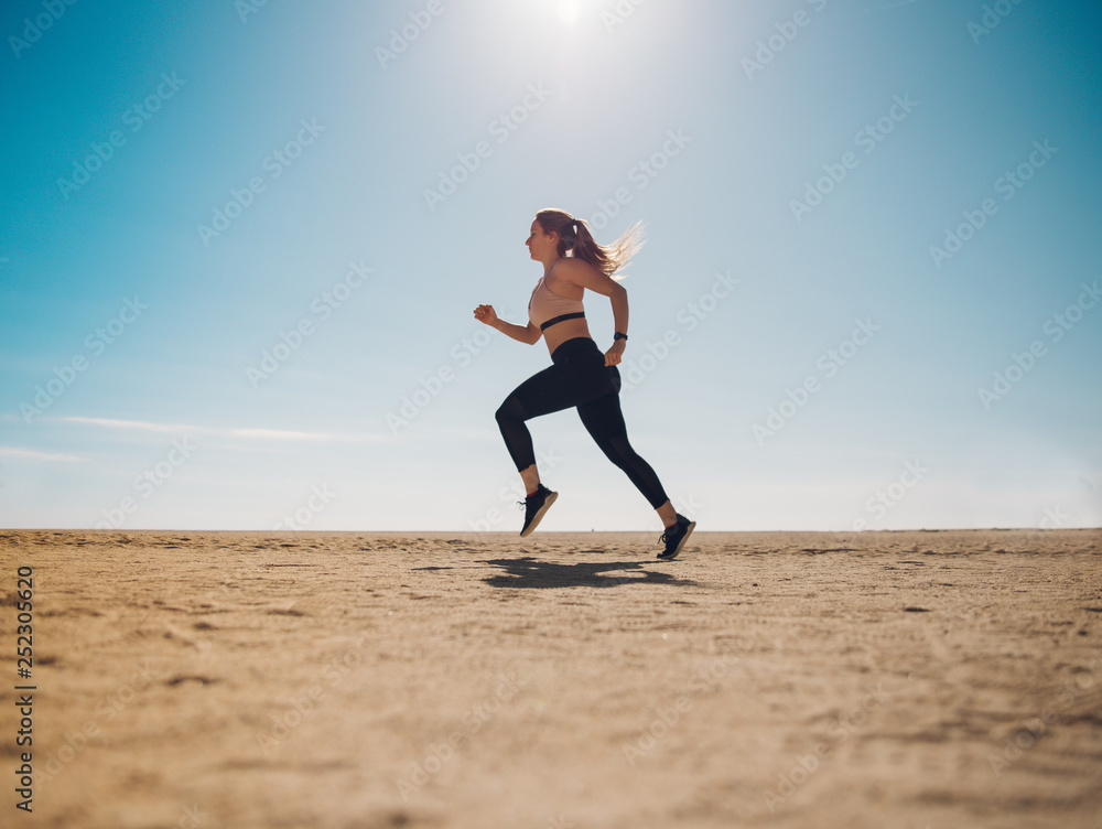 blondie woman wearing sport cloth running on the beach blondie woman wearing sport cloth running on the beach