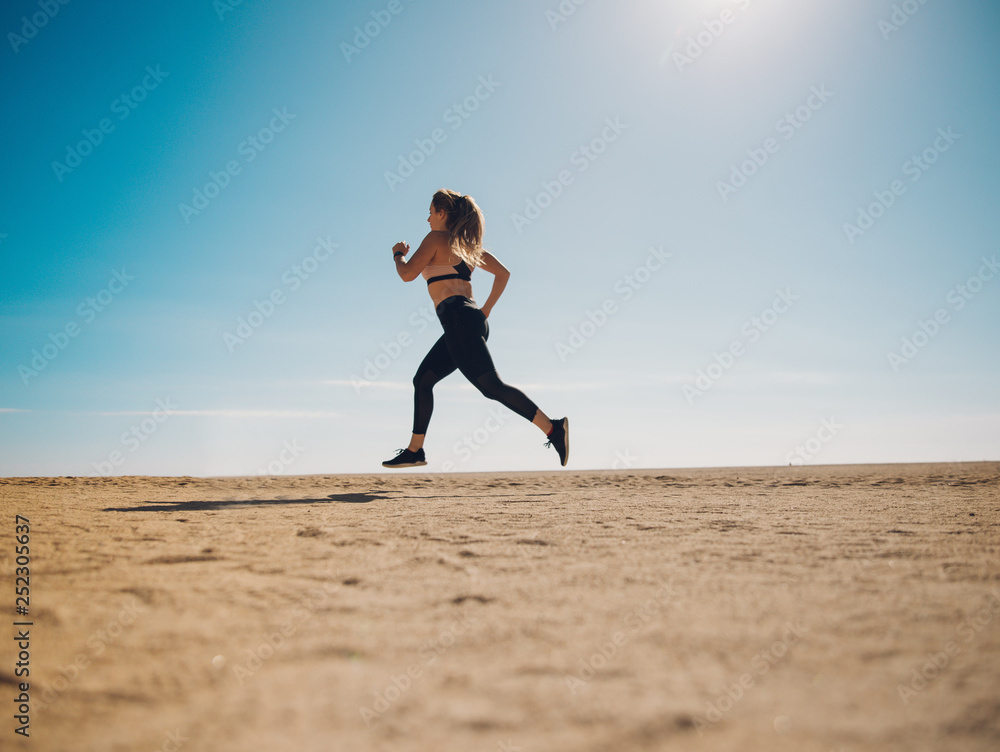 blondie woman wearing sport cloth running on the beach