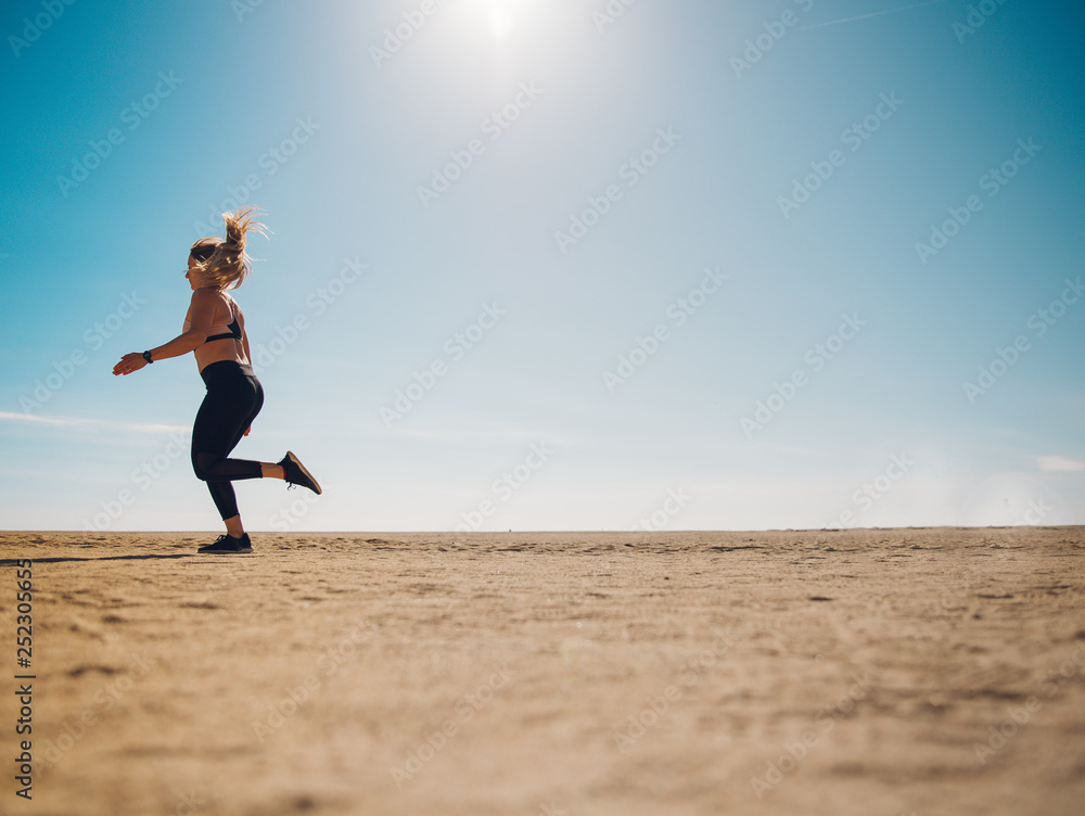 blondie woman wearing sport cloth running on the beach blondie woman wearing sport cloth running on the beach