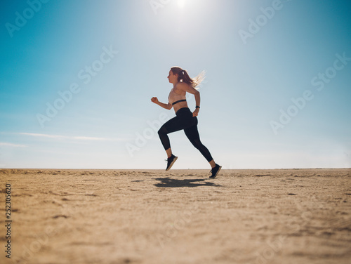 Fototapeta Naklejka Na Ścianę i Meble -  blondie woman wearing sport cloth running on the beach