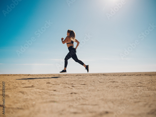 blondie woman wearing sport cloth running on the beach