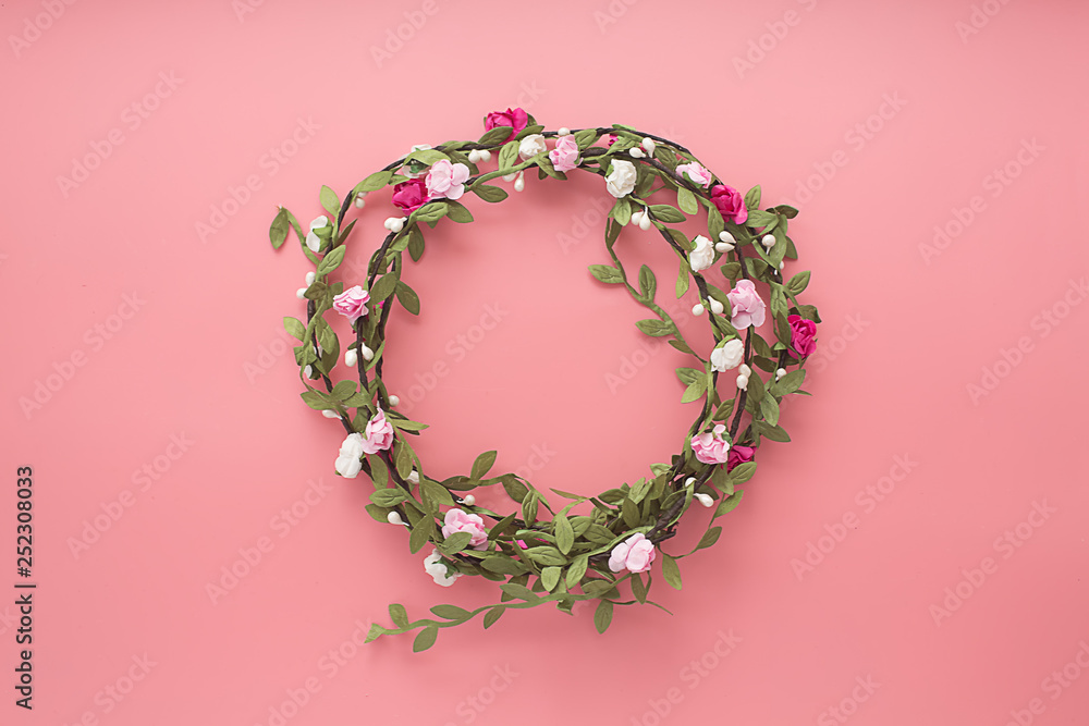 Wreaths of flowers and leaves on a pink background. Flat lay, copy space, top view. Flowers composition.