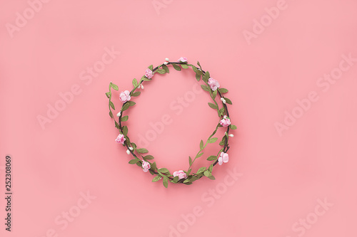 wreath of flowers and leaves on a pink background. Flat lay, copy space, top view. Flowers composition.