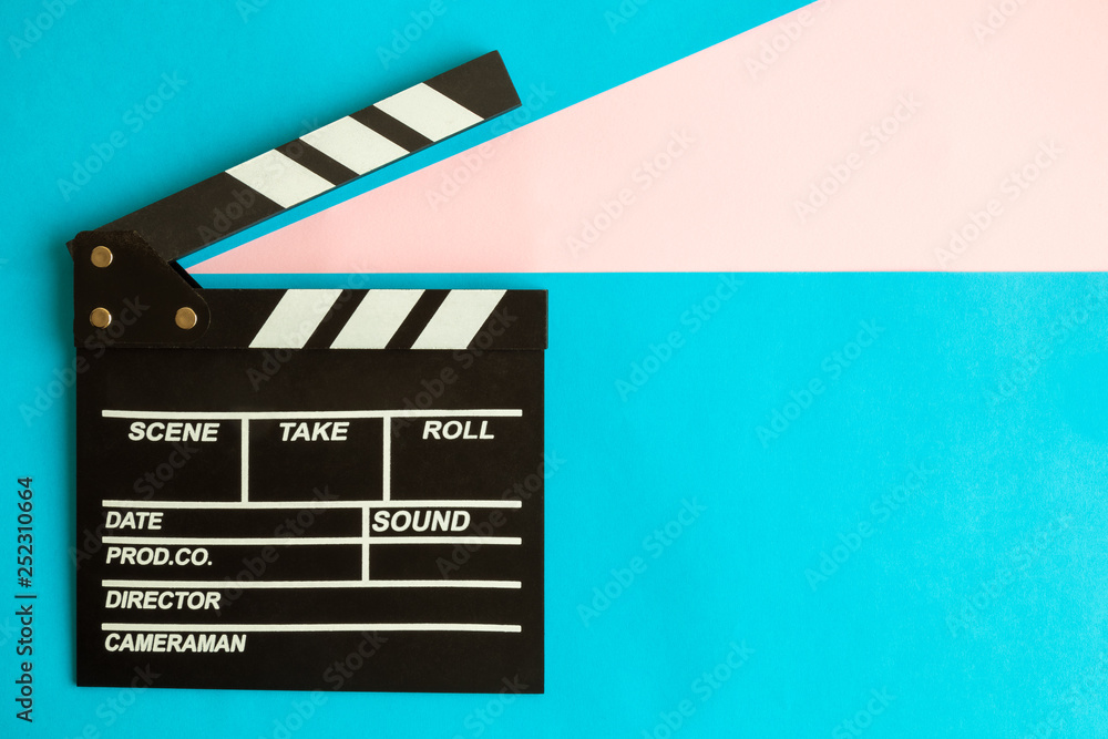 Flat lay of clapperboard against blue background.