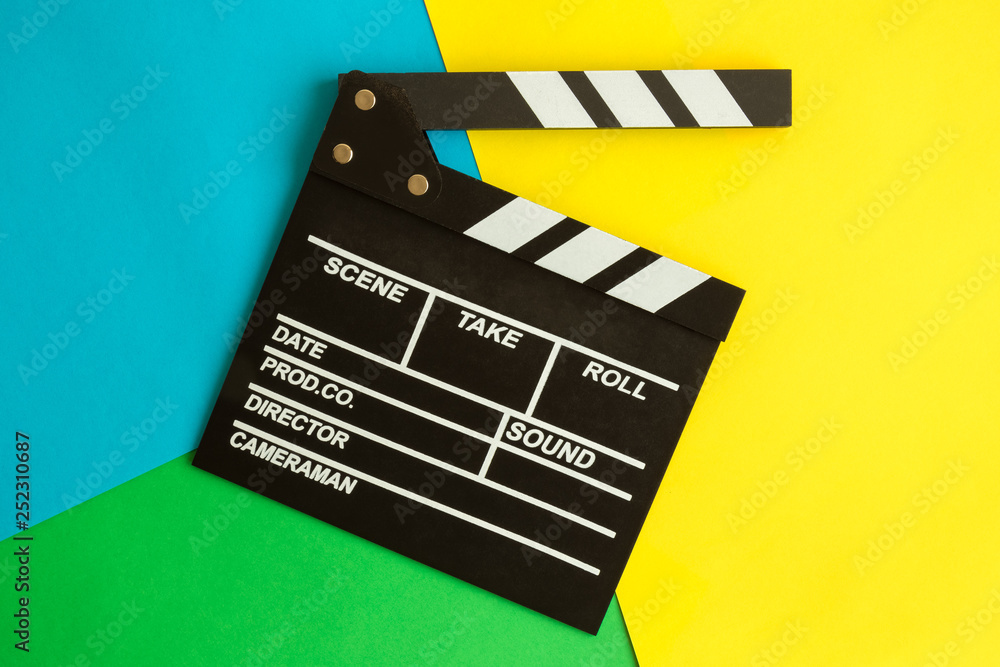 Flat lay of clapperboard against multicolored background.