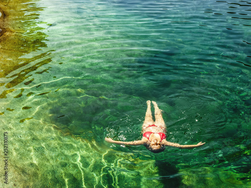 Woman floating in the clear water of a mountain river photo