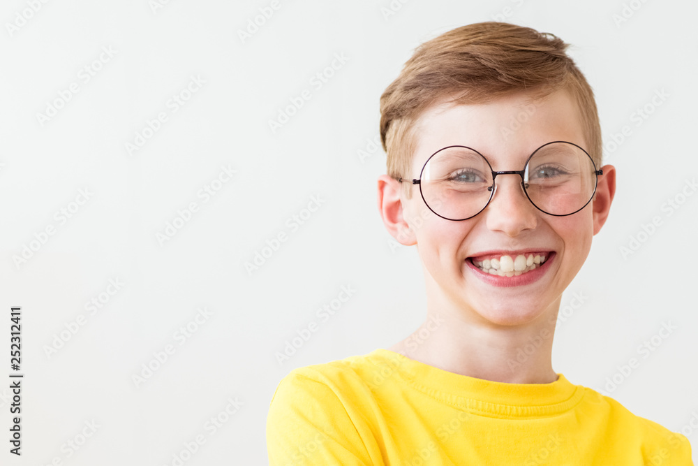 Handsome laughing teen boy with big glasses and yellow t-shirt Handsome laughing teen boy with big glasses and yellow t-shirt