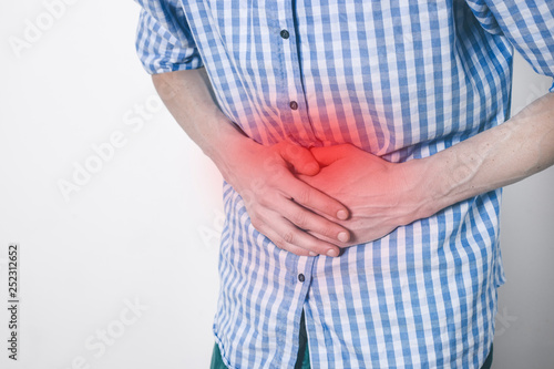 Indigestion. A man holds his stomach from heartburn. Diarrhea. Acid in the esophagus. 