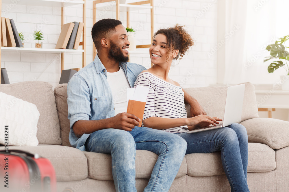 Planning tour. African-american couple using laptop at home Planning tour. African-american couple using laptop at home