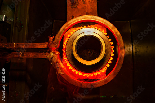 Foto closeup calcining hot metal steel gear parts in a factory induction furnace with