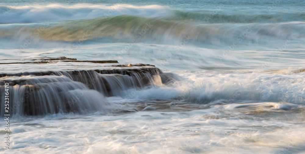 Rocky seashore with wavy ocean and waves crashing on the rocks Rocky seashore with wavy ocean and waves crashing on the rocks