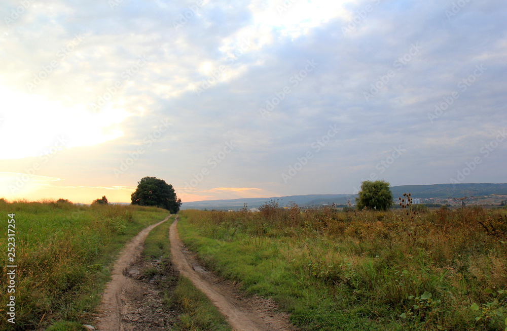 Landscape with meadow and road at sunset Landscape with meadow and road at sunset