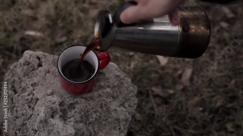 Red and Blue cups of coffee on the wooden bench. Poured from a coffee pot