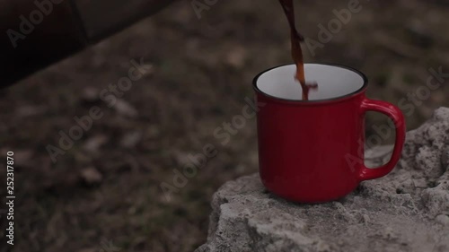 Red cup of coffee on the stone.