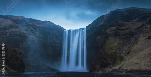 Breathtaking view of magnificent waterfall and rough cliff on beautiful cloudy day in Iceland © ADDICTIVE STOCK