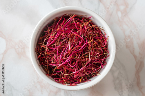 Red beet sprouts in a bowl, top view