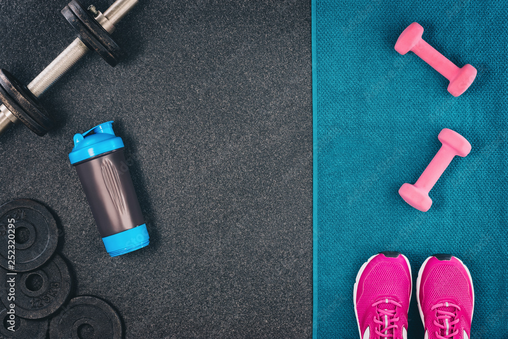 Fitness or bodybuilding concept background. Product photograph of old iron dumbbells on black grey, conrete floor in the gym. Photograph taken from above, top view with lots of copy space Fitness or bodybuilding concept background. Product photograph of old iron dumbbells on black grey, conrete floor in the gym. Photograph taken from above, top view with lots of copy space
