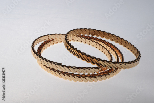 four golden bracelets on white background 