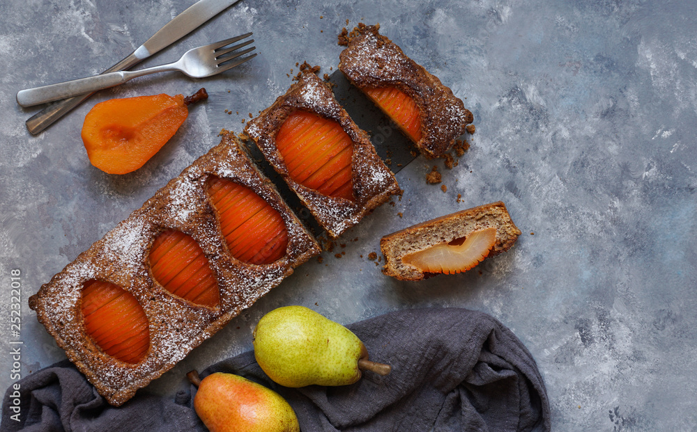 From above cutlery and pear frangipane tart near fresh fruits and