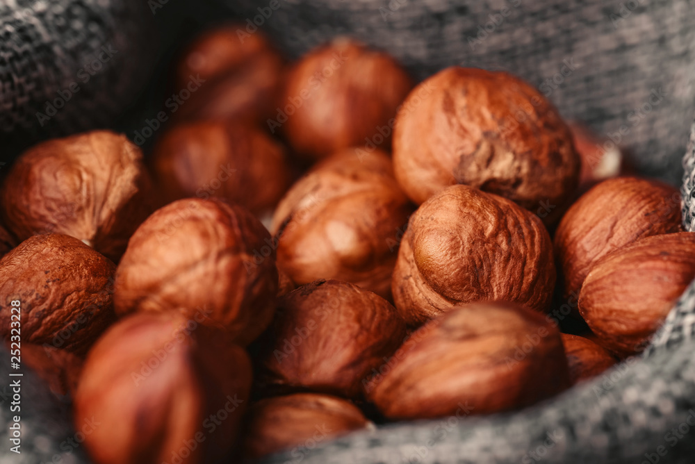 Hazelnuts, filbert in burlap sack on wooden backdrop. heap or stack of hazelnuts. Hazelnut background, healthy food Hazelnuts, filbert in burlap sack on wooden backdrop. heap or stack of hazelnuts. Hazelnut background, healthy food