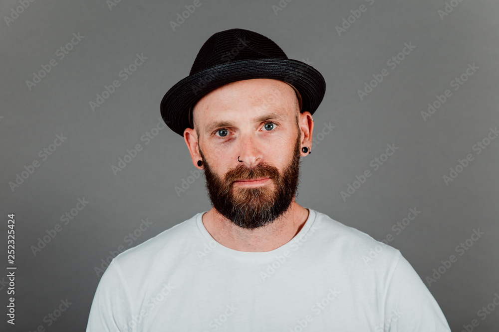 Bearded hairless hipster in t-shirt and hat on black background Bearded hairless hipster in t-shirt and hat on black background