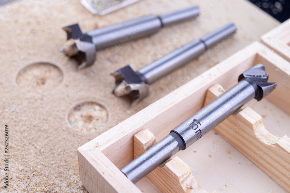 Carpentry drill, used to mount furniture hinges. A cutter used to mount furniture from chipboard. Dark background. Carpentry drill, used to mount furniture hinges. A cutter used to mount furniture from chipboard. Dark background.