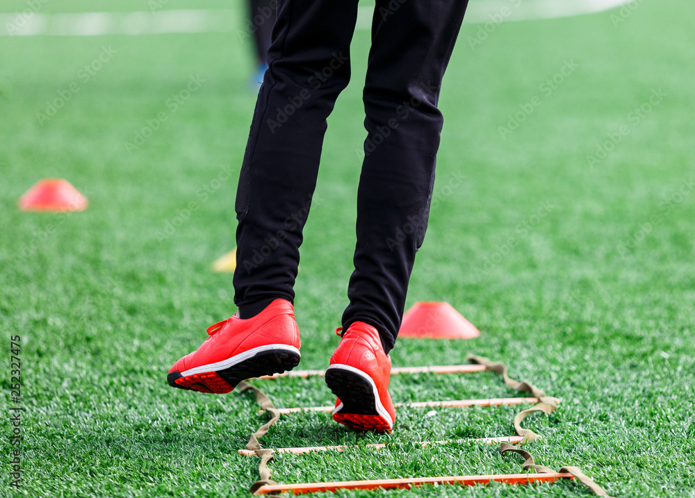 Fototapeta premium Boys at black red sportswear run, dribble, attack on football field. Young Soccer players with ball on green grass. Training, football, active lifestyle for kids