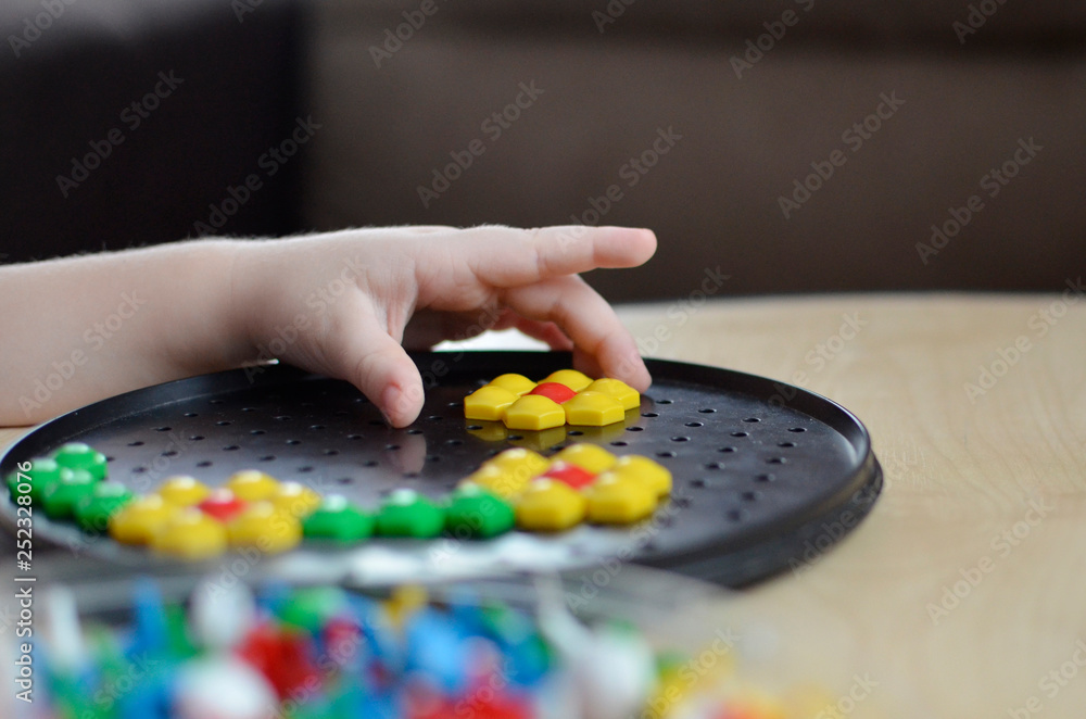 Little child playing with mosaic