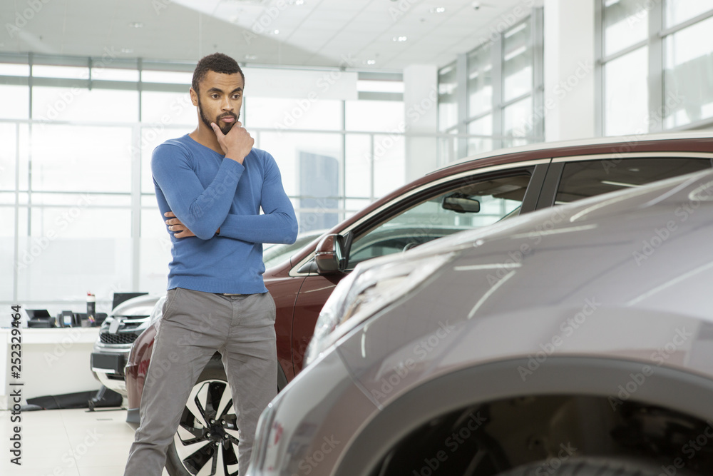 Handsome young African man buying a new automobile at the dealership Handsome young African man buying a new automobile at the dealership