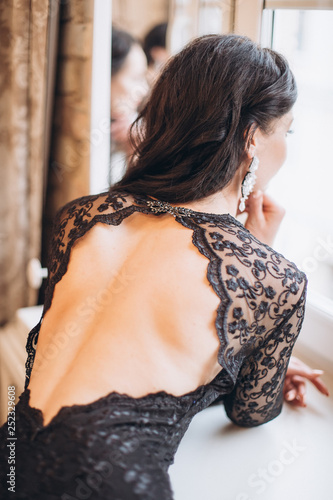 Close up indoors portrait of young gorgeous sexy elegant lady in black lace fashion dress in diamonds jewelery