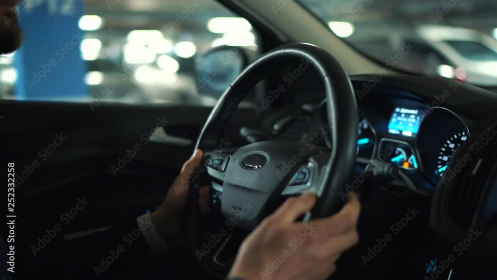 Man driving in innovative automated car using self-parking autopilot for parking on street Man driving in innovative automated car using self-parking autopilot for parking on street