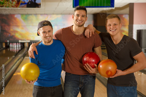 Young handsome guys friends bowling together photo