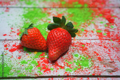 Obraz na płótnie Zwei Erdbeeren auf buntem Hintergrund w salonie