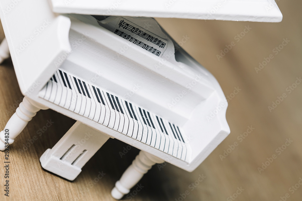 White tiny piano music close up on a wooden background White tiny piano music close up on a wooden background