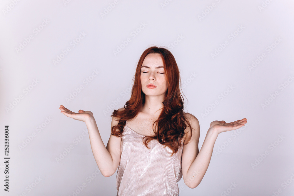 Young positive ginger girl with freckles isolated posing in studio on grey background. Natural beauty, casual, yoga, harmony, healthy lifestyle concept