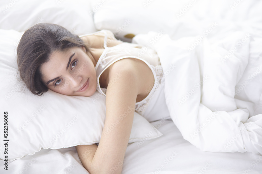 beautiful young woman basking in bed in the morning. Beautiful Model face looks sexy in camera beautiful young woman basking in bed in the morning. Beautiful Model face looks sexy in camera