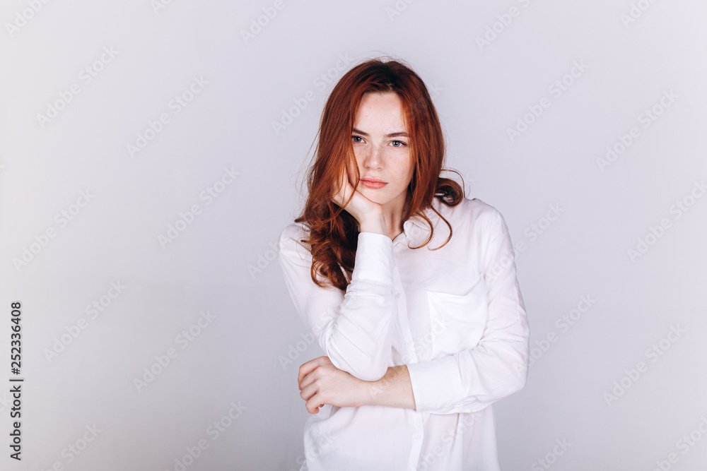Young serious tender depressed woman on grey background Young serious tender depressed woman on grey background