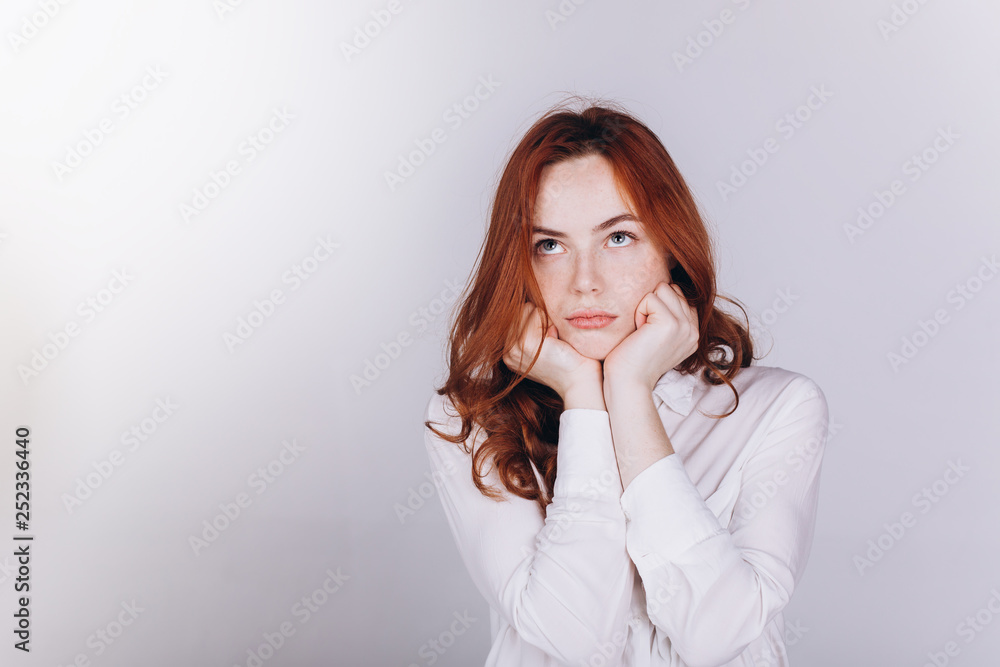 Young serious tender depressed woman on grey background Young serious tender depressed woman on grey background