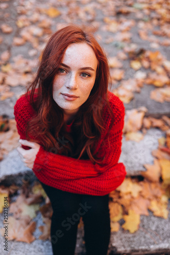 Close up outdoor portrait of caucasian ginger dreaming and smiling sensual tender young girl in autumn park. Beauty, nature, seasons, emotions concept