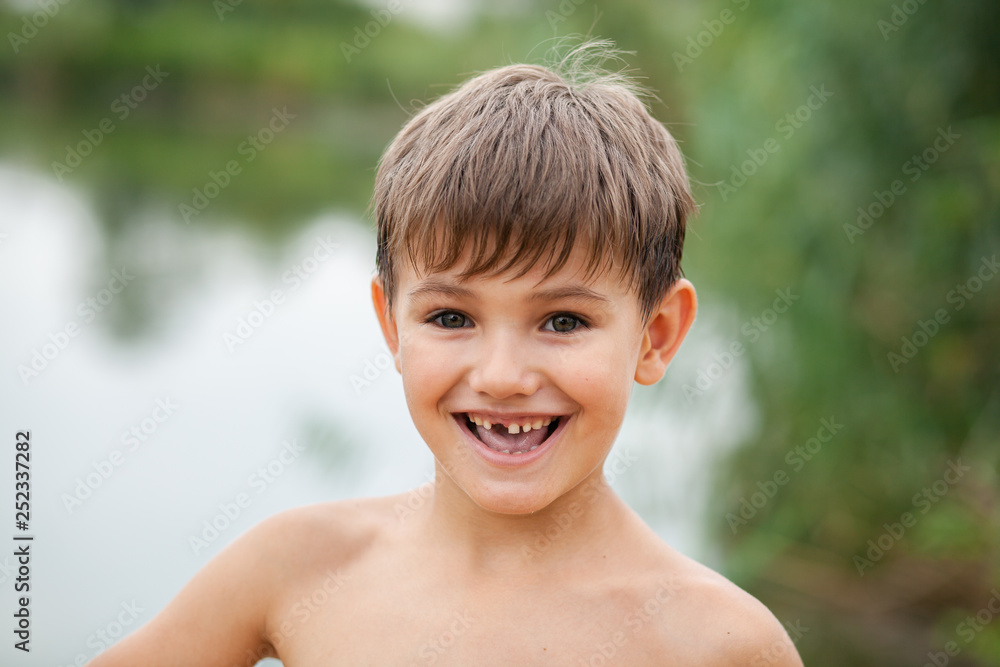portrait of a toothless child 5-6 years old in nature in summer