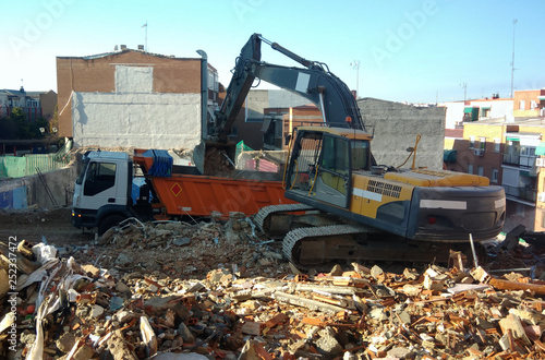 demolition team at construction site, excavator disposes demolition rubbish intro truck
