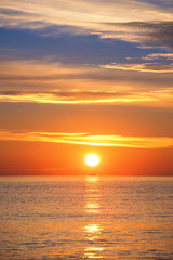 Fototapete Orange Frachtschiff bei Sonnenaufgang am Meer  © ValentinValkov